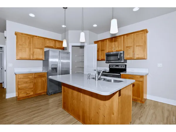 a kitchen with kitchen island granite countertop a sink appliances and cabinets