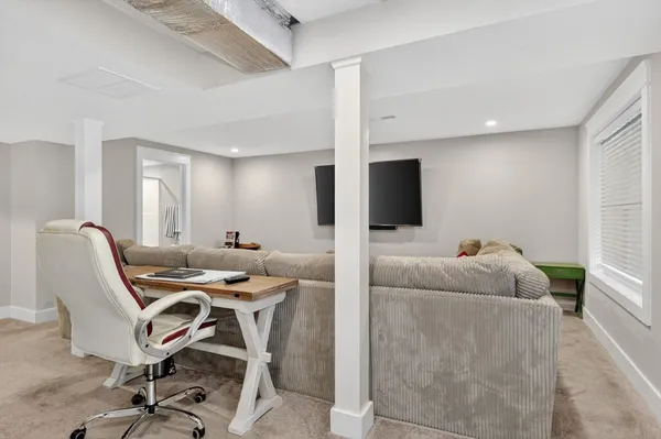 a work room with furniture and a flat screen tv