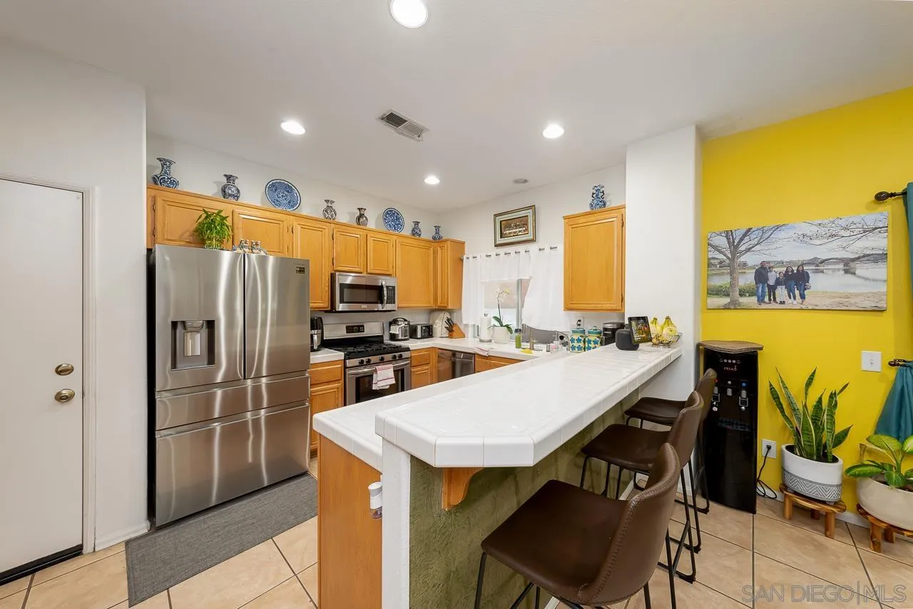 1322 Mill Valley Road Chula Vista, CA 91913 - Photo 9 of 25 a kitchen with a table chairs refrigerator and microwave