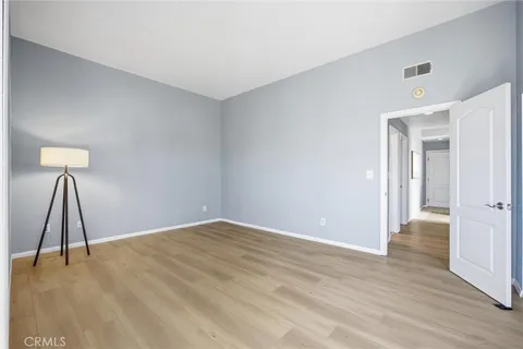 a view of a room with wooden floor and a ceiling fan