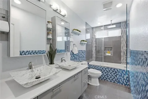 a bathroom with a sink vanity mirror and toilet