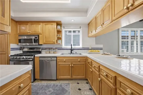 a kitchen with stainless steel appliances granite countertop a sink and a stove