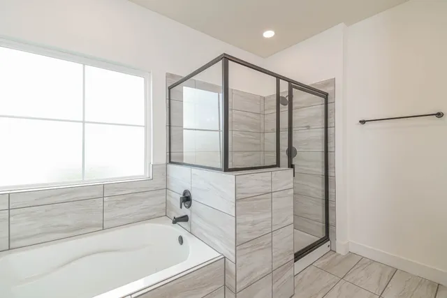 a bathroom with a bathtub and next to a window