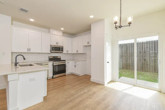 a kitchen with kitchen island a sink stainless steel appliances and cabinets