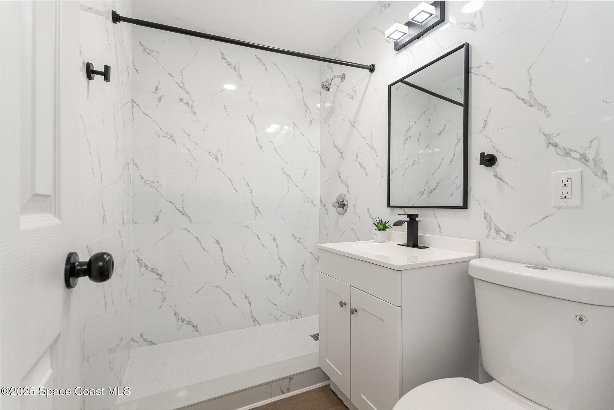 1029 Illinois Road Cocoa, FL 32927 - Photo 19 of 27 a bathroom with a sink toilet and shower