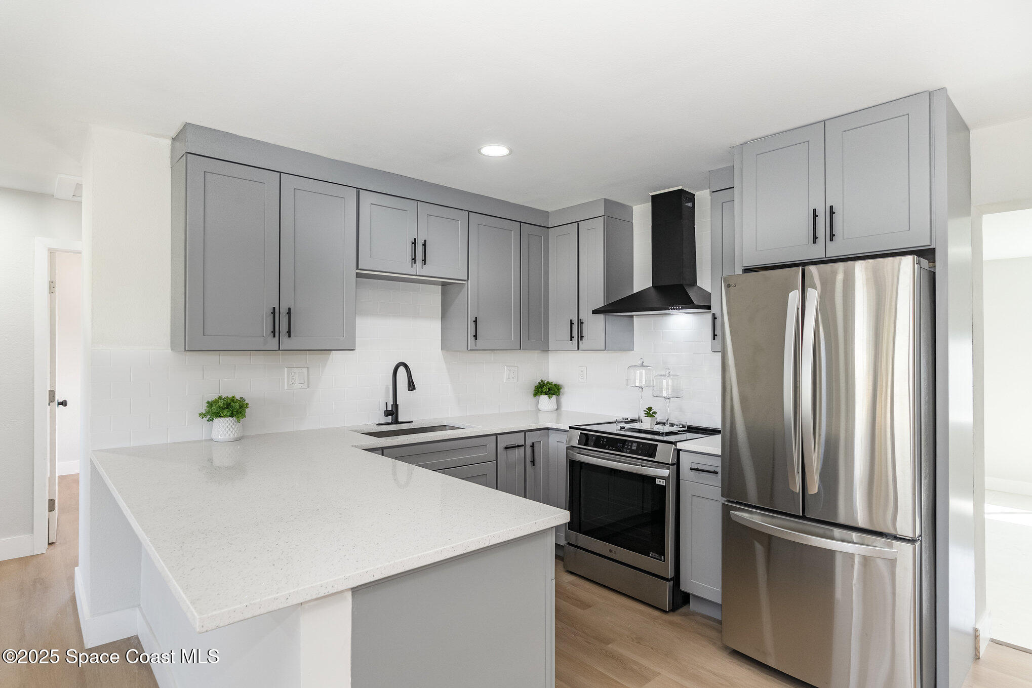 1029 Illinois Road Cocoa, FL 32927 - Photo 7 of 27 a kitchen with stainless steel appliances a refrigerator sink and microwave
