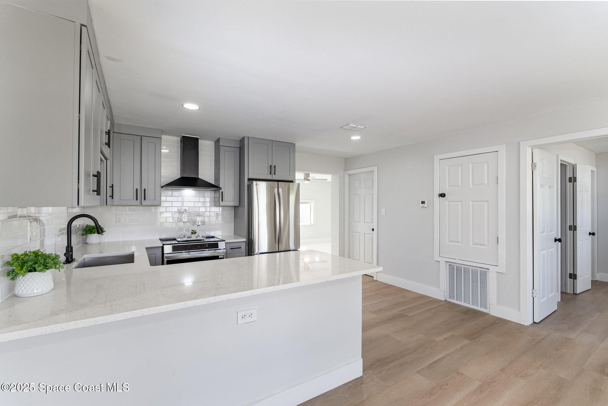 1029 Illinois Road Cocoa, FL 32927 - Photo 8 of 27 a kitchen with stainless steel appliances a sink a stove a refrigerator cabinets and a counter top space