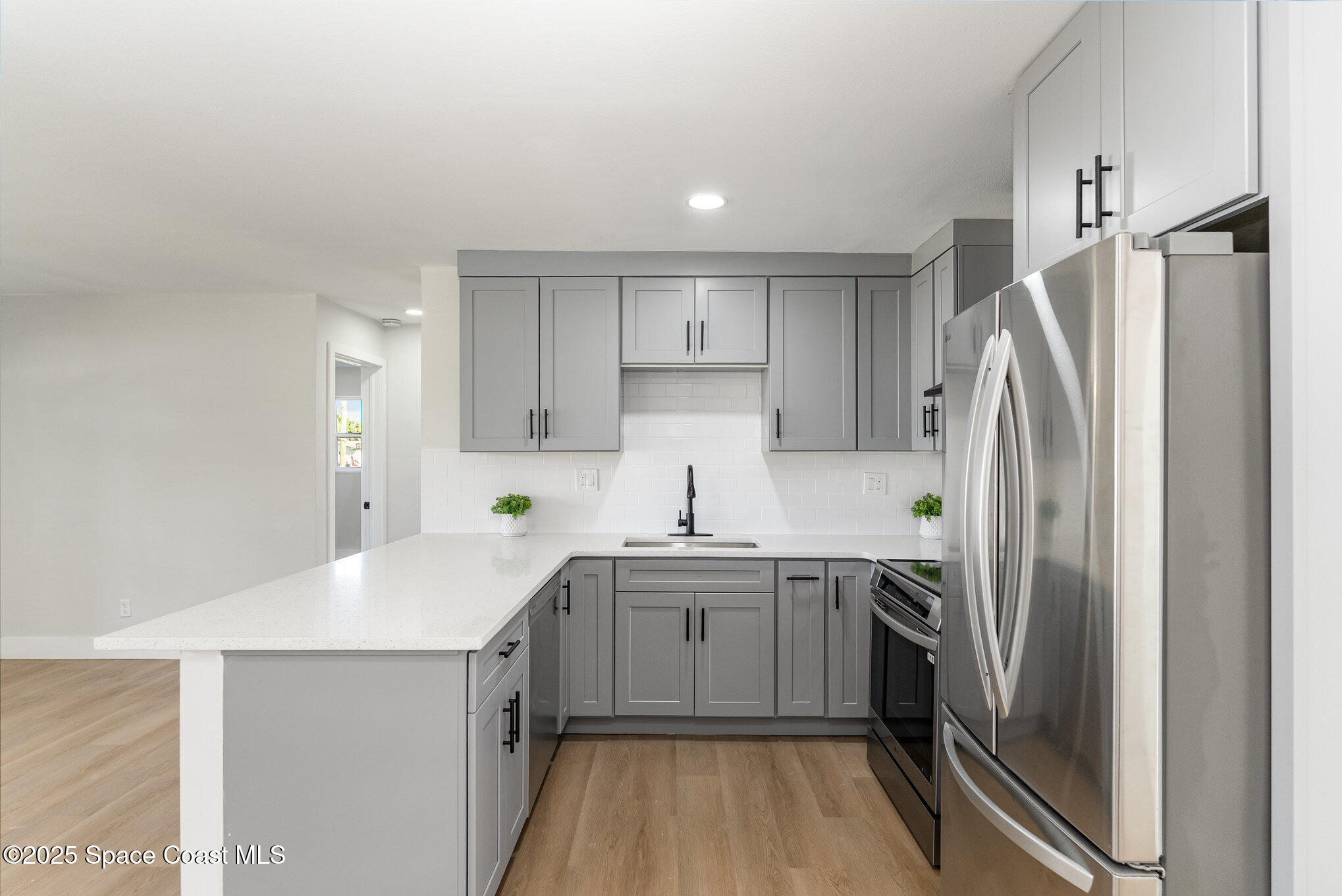 1029 Illinois Road Cocoa, FL 32927 - Photo 9 of 27 a kitchen with a sink a refrigerator and cabinets