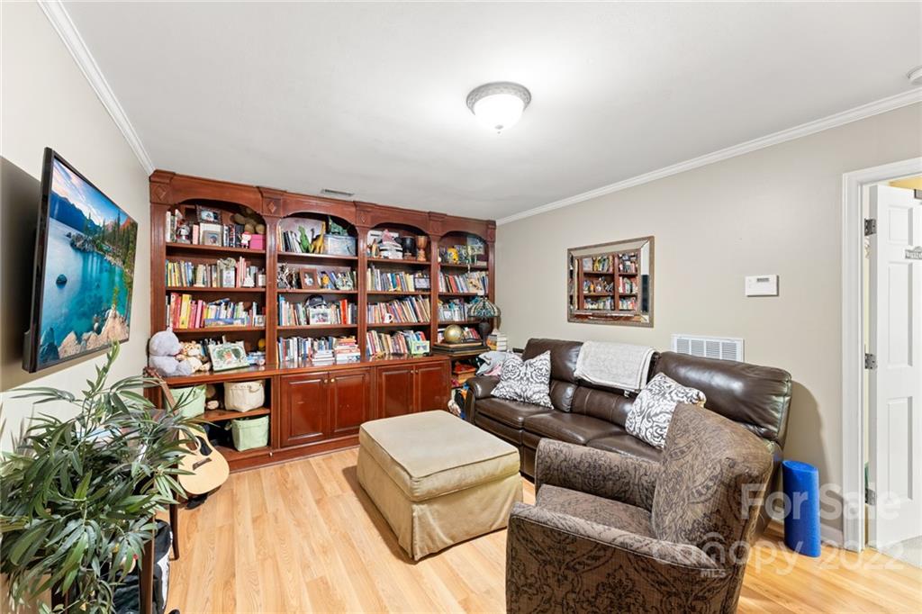 620 Trail Ridge Road Matthews, NC 28105 - Photo 28 of 34 a living room with furniture a rug and a bookshelf