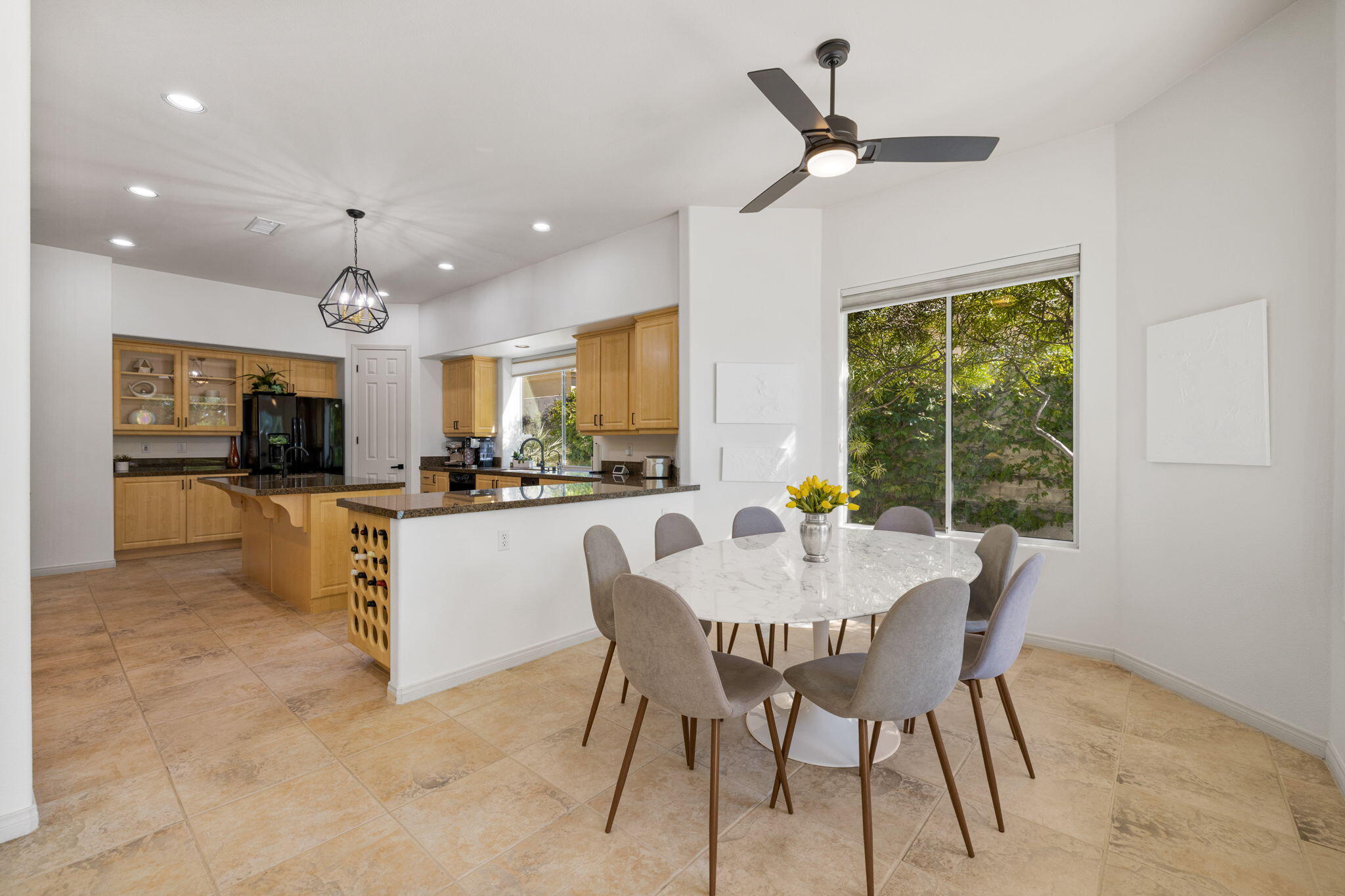 19 Trafagar Square Rancho Mirage, CA 92270 - Photo 38 of 54 a dining room with furniture a kitchen view and a chandelier