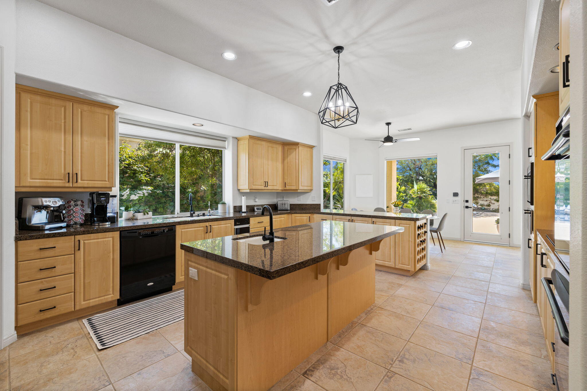 19 Trafagar Square Rancho Mirage, CA 92270 - Photo 4 of 54 a large kitchen with kitchen island granite countertop a large center island attached withe living room