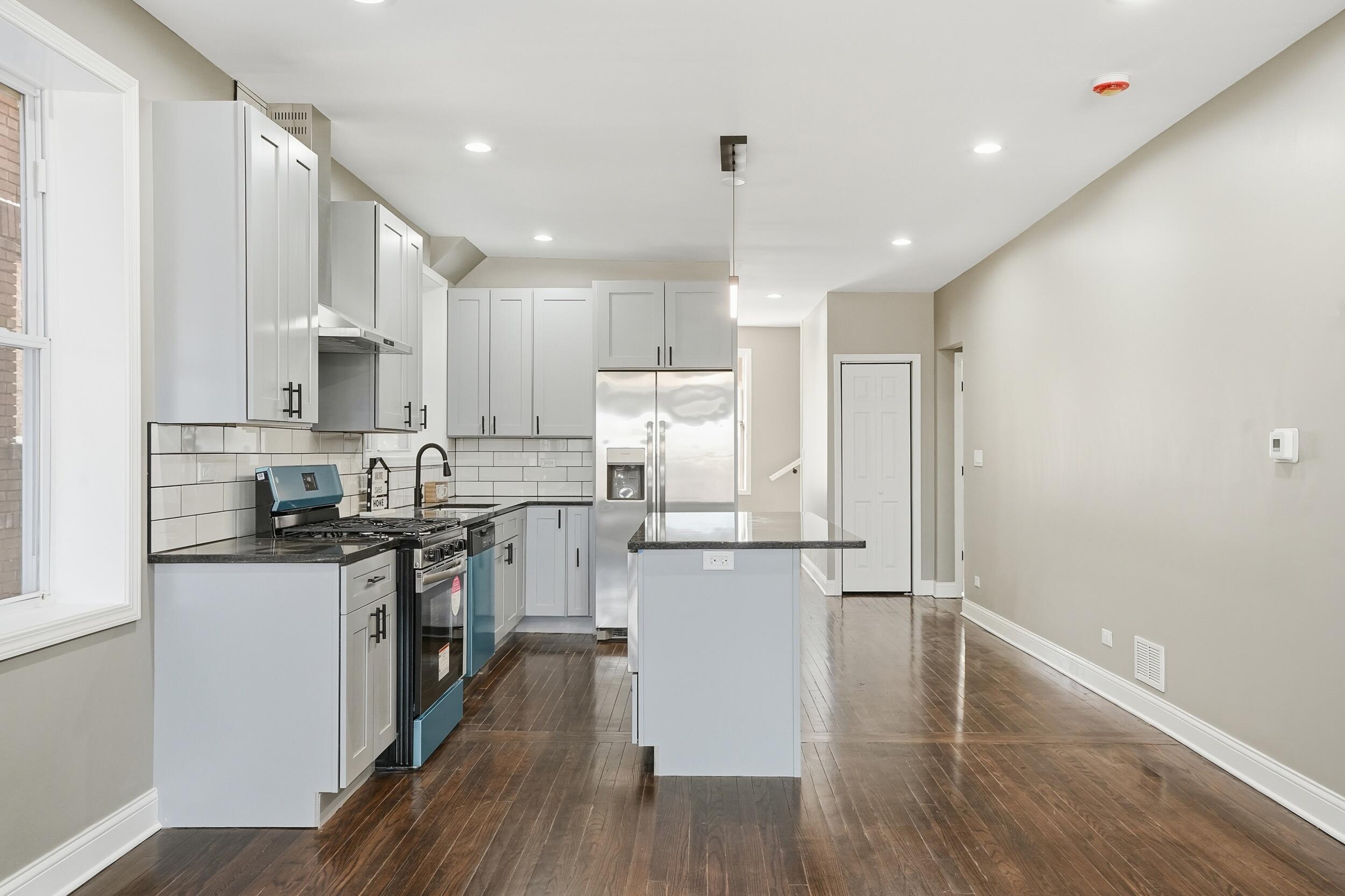1320 Delaware Street Gary, IN 46407 - Photo 8 of 20 a kitchen with kitchen island white cabinets and stainless steel appliances
