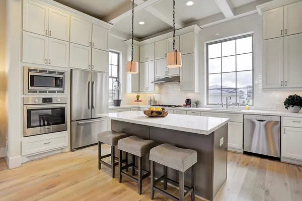 a kitchen with white cabinets and window