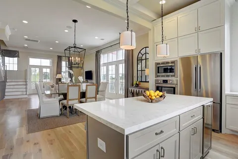 a kitchen with sink a refrigerator and chairs