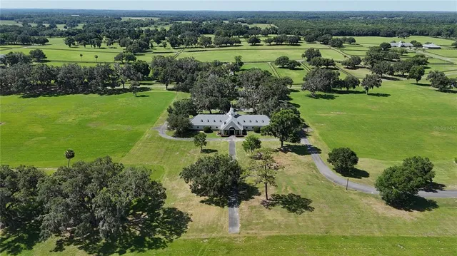 an aerial view of a house with a garden and lake view