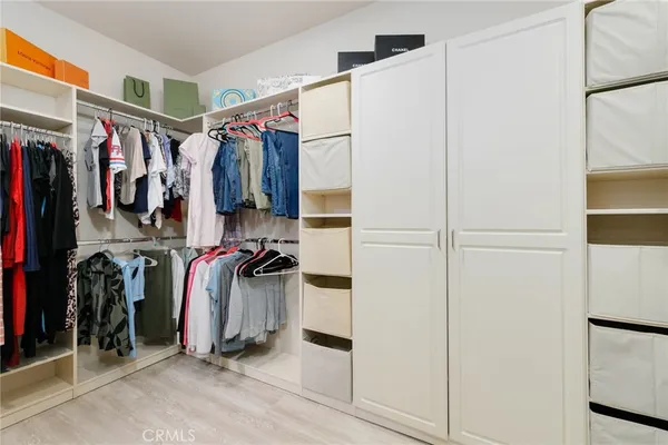 a spacious bedroom with a bed and a dresser