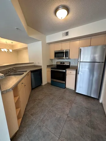 a kitchen with stainless steel appliances granite countertop a refrigerator and a stove
