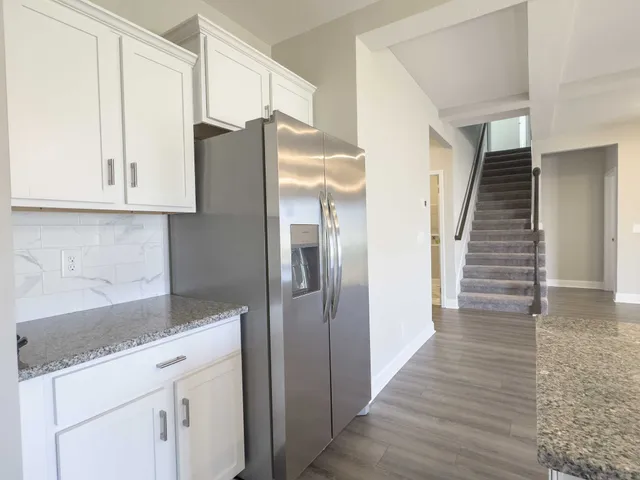 a kitchen with a refrigerator an oven and cabinets