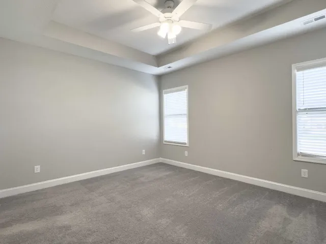 an empty room with a window and a ceiling fan
