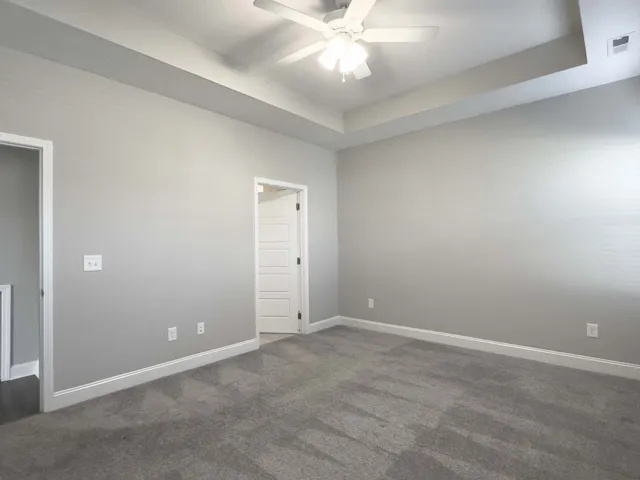 an empty room with a chandelier fan and closet area