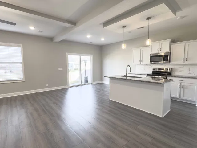 a kitchen with stainless steel appliances kitchen island wooden cabinets and a wooden floor