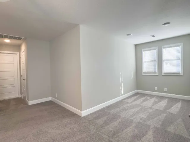 an empty room with windows and closet