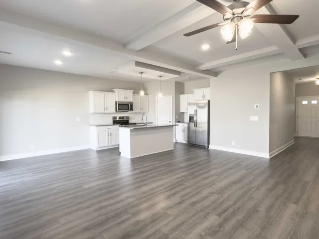 a view of kitchen with refrigerator microwave and stove with wooden floor