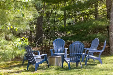 a view of a chairs and table in backyard