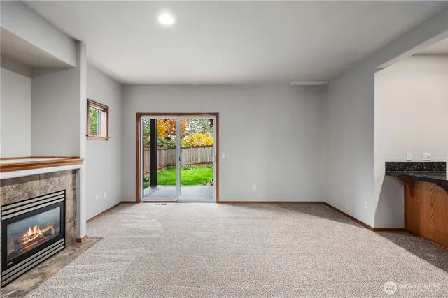 a view of an empty room with a fireplace and a window
