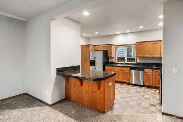 a kitchen with stainless steel appliances granite countertop a stove a sink and a refrigerator