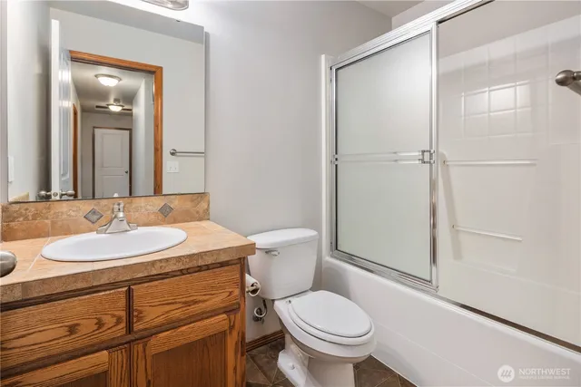 a bathroom with a sink toilet vanity and shower