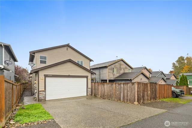a view of a house with a yard and large tree