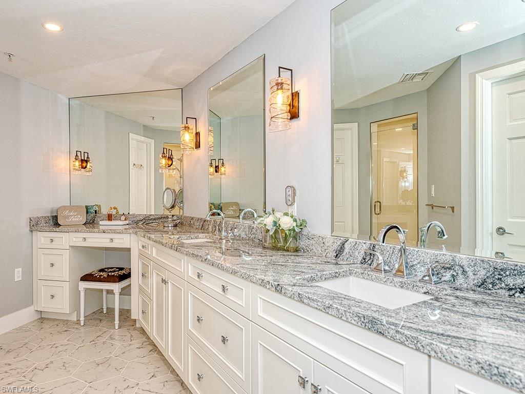 60 Seagate Drive, Unit 406 Naples, FL 34103 - Photo 13 of 26 a bathroom with a sink double vanity granite and a mirror