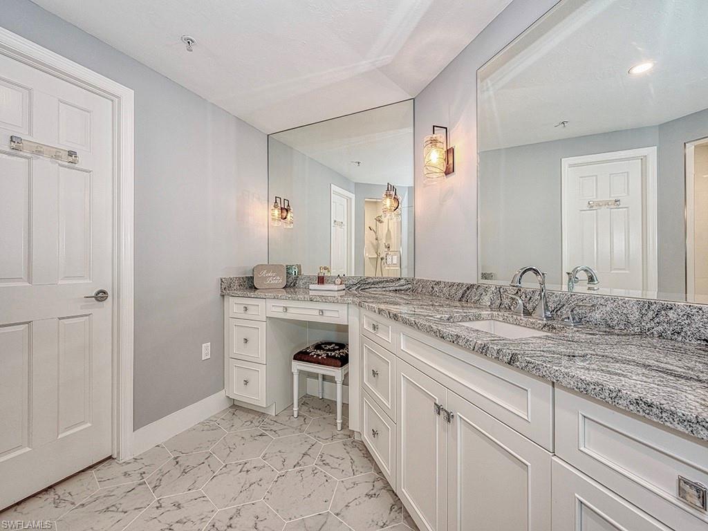 60 Seagate Drive, Unit 406 Naples, FL 34103 - Photo 14 of 26 a bathroom with a granite countertop sink and a mirror