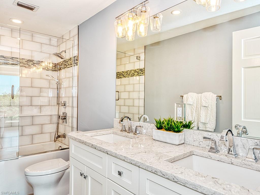 60 Seagate Drive, Unit 406 Naples, FL 34103 - Photo 16 of 26 a bathroom with a granite countertop sink a toilet and shower