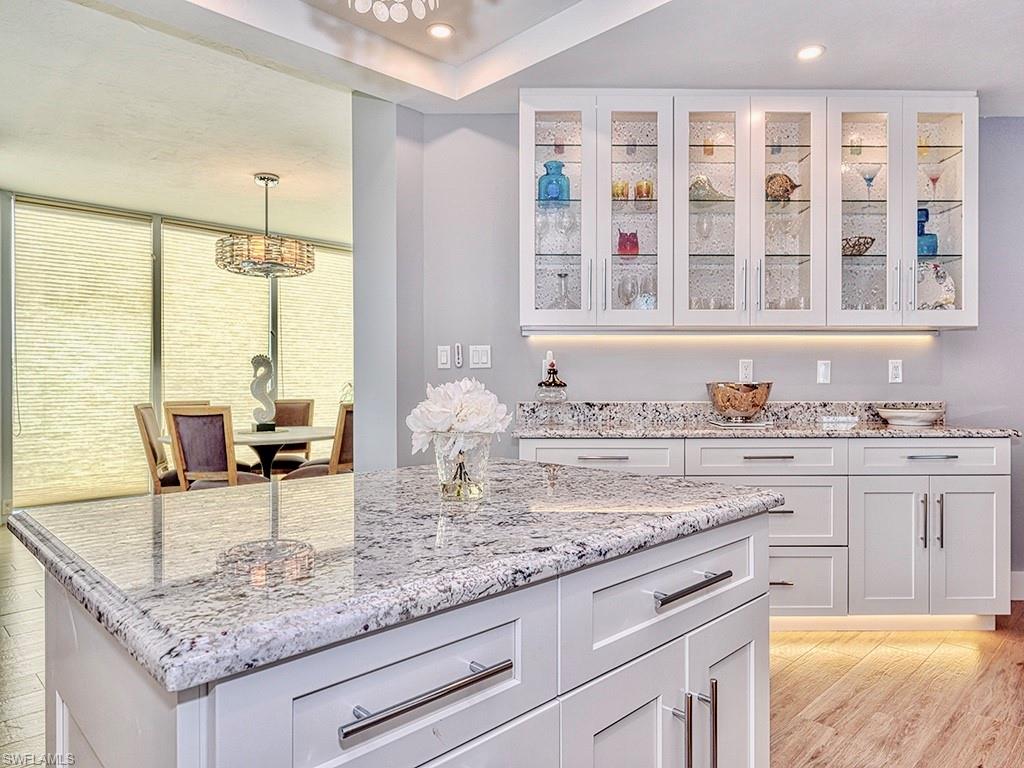 60 Seagate Drive, Unit 406 Naples, FL 34103 - Photo 7 of 26 a kitchen with granite countertop sink and cabinets