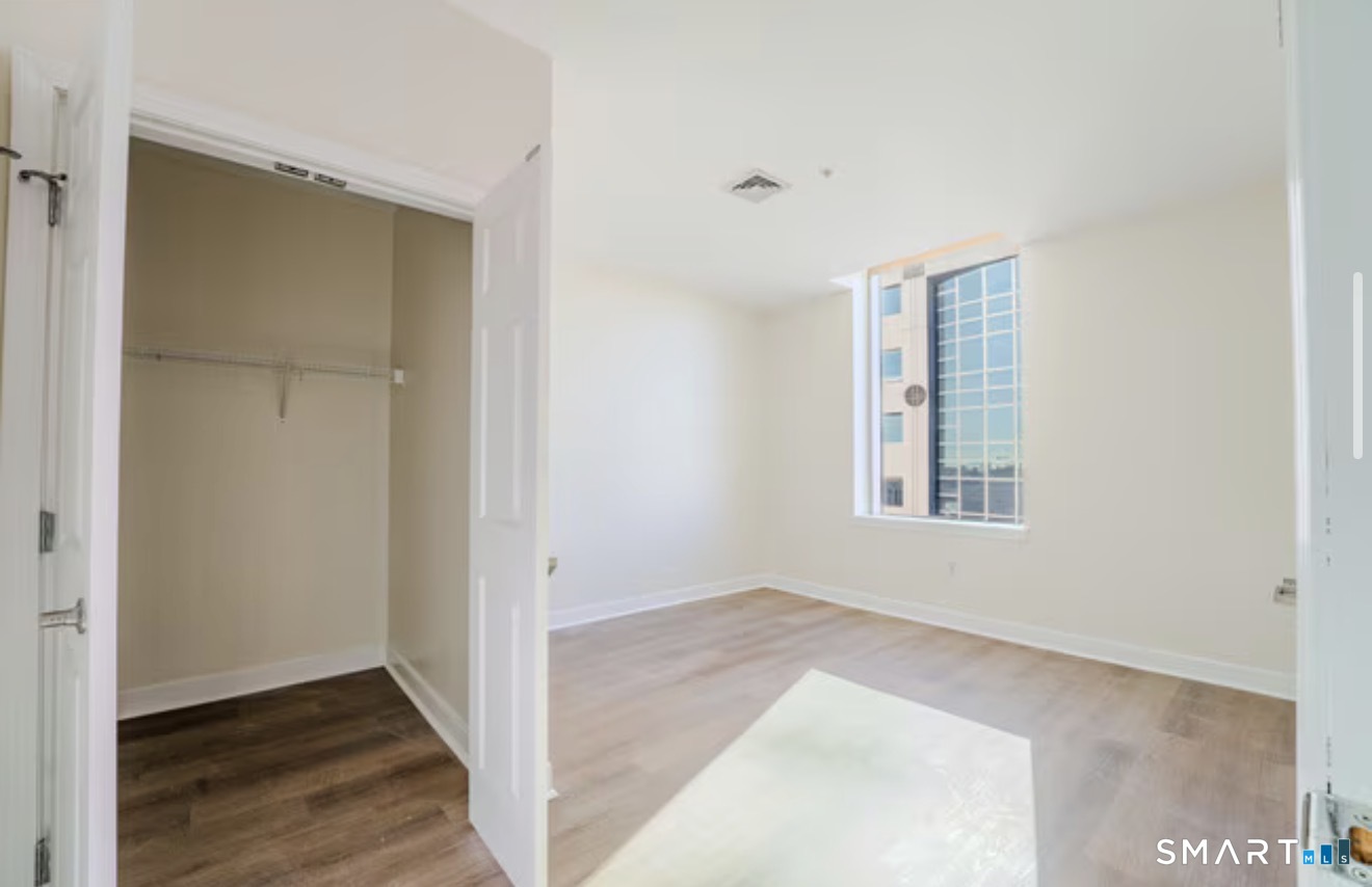 333 State Street, Unit 410 Bridgeport, CT 06604 - Photo 5 of 6 a view of an empty room with wooden floor and a window