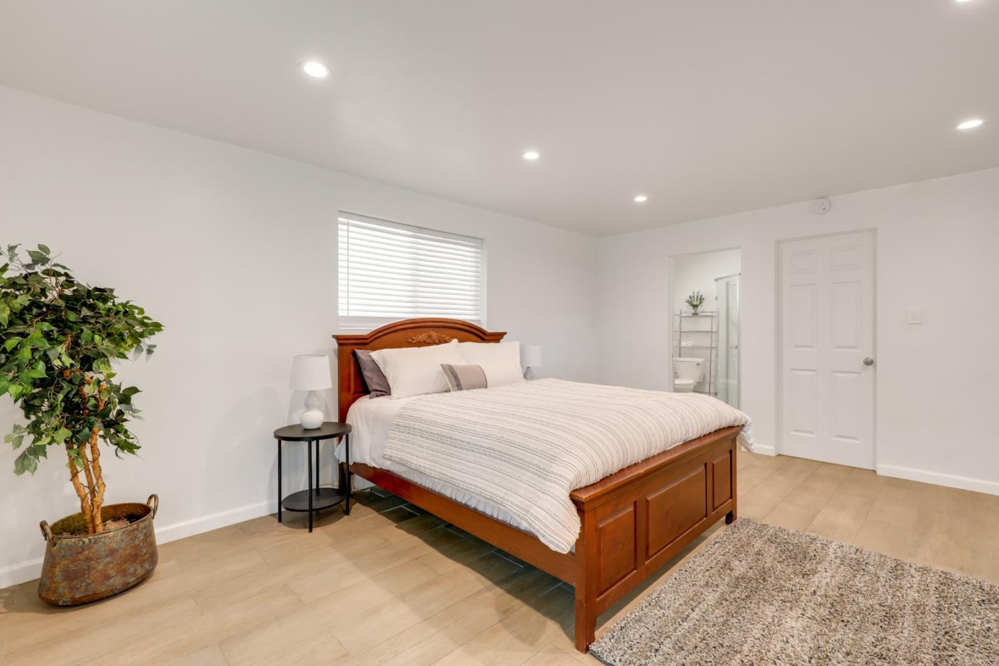 19235 Cachagua Road Carmel Valley, CA 93924 - Photo 28 of 34 a spacious bedroom with a bed and a potted plant