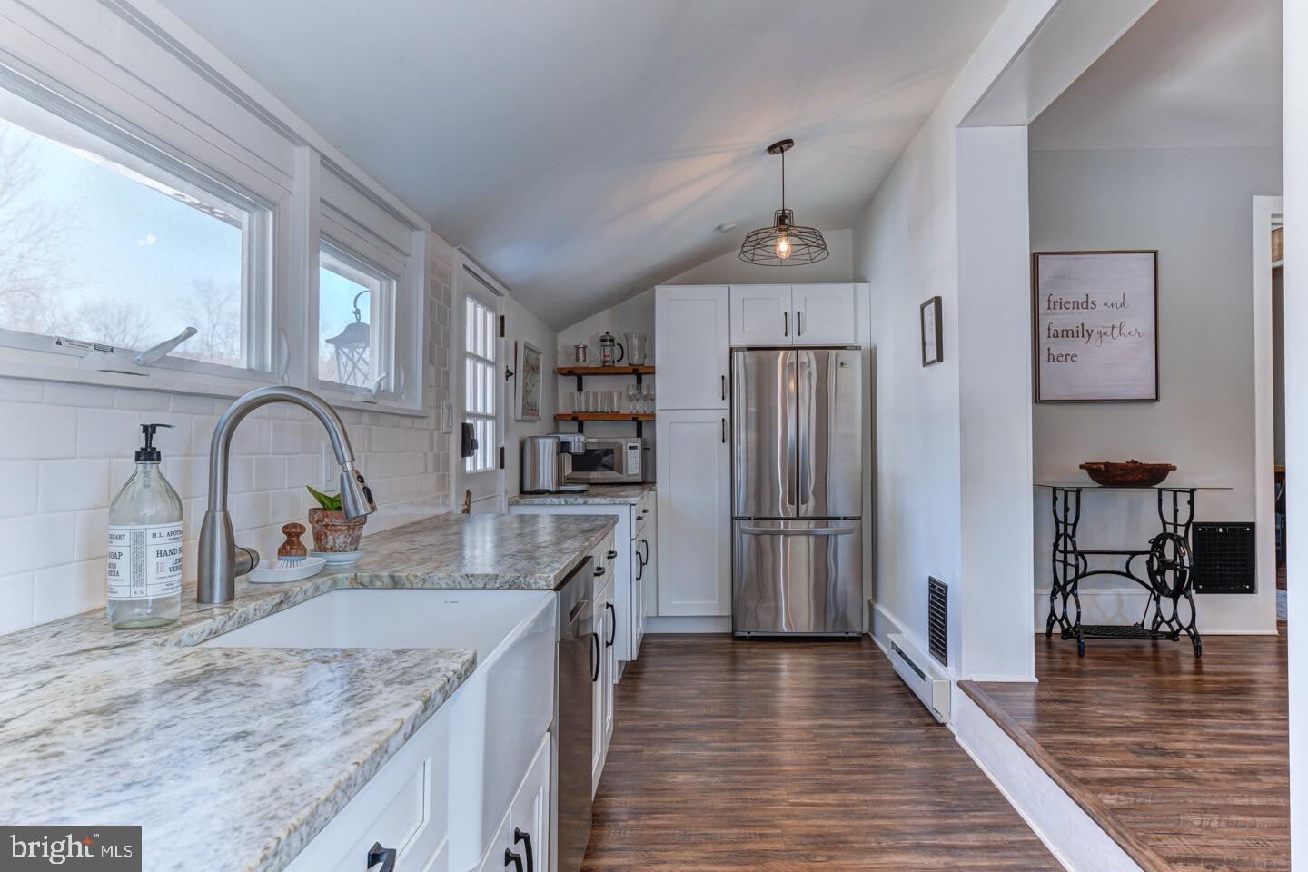 a kitchen with stainless steel appliances granite countertop a refrigerator a stove and a sink with cabinets