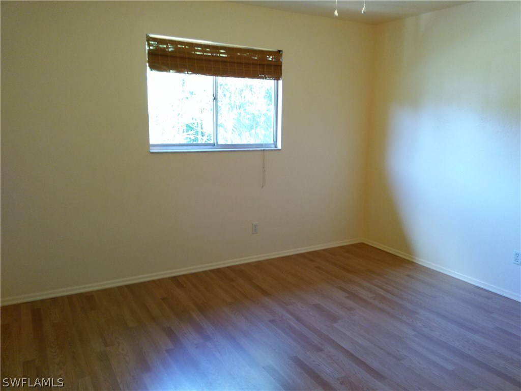 8438 Robin Road Fort Myers, FL 33967 - Photo 17 of 24 an empty room with wooden floor and a window