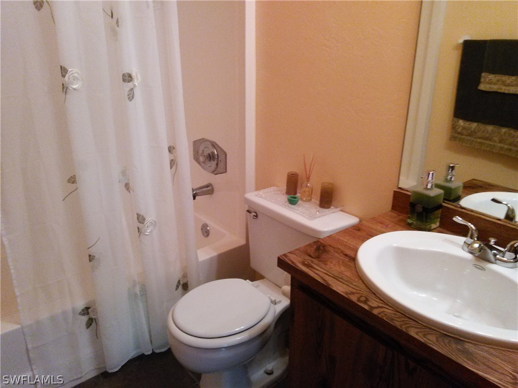 8438 Robin Road Fort Myers, FL 33967 - Photo 20 of 24 a bathroom with a granite countertop sink toilet and mirror