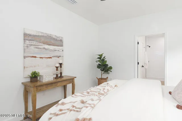 a bedroom with a bed and a potted plant