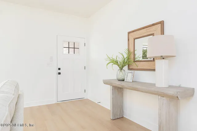 a bathroom with a sink a mirror and a potted plant