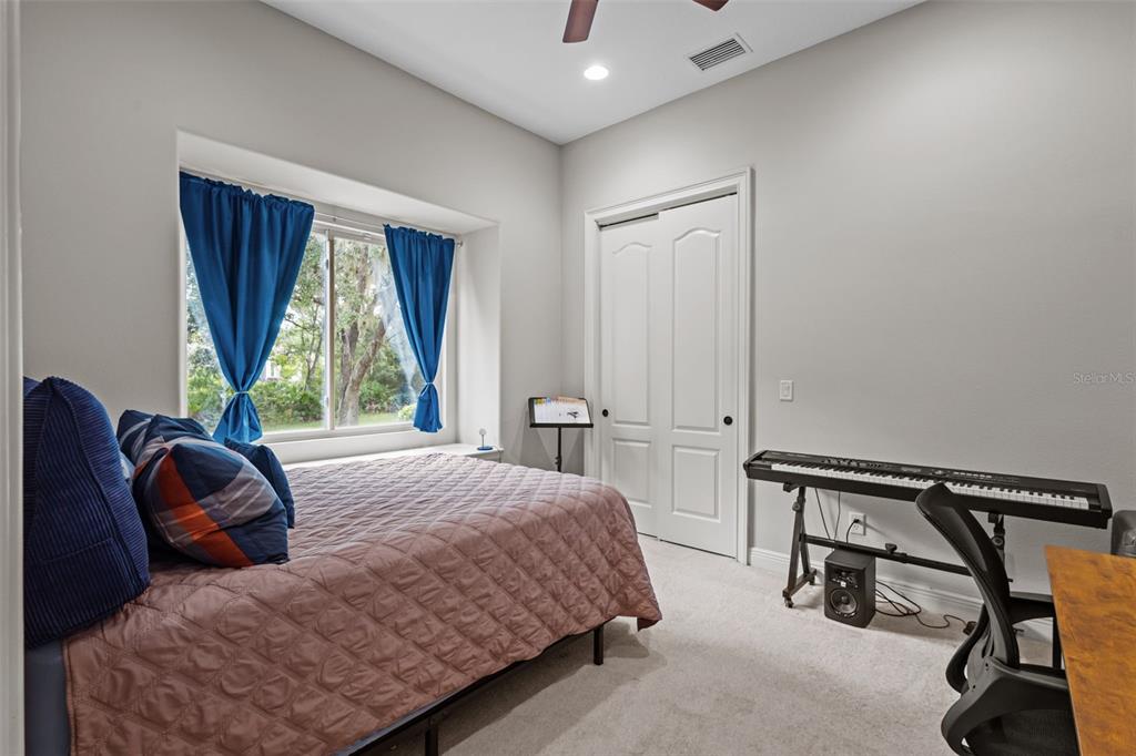 10826 Alico Pass New Port Richey, FL 34655 - Photo 26 of 51 a bedroom with a bed a lamp and windows