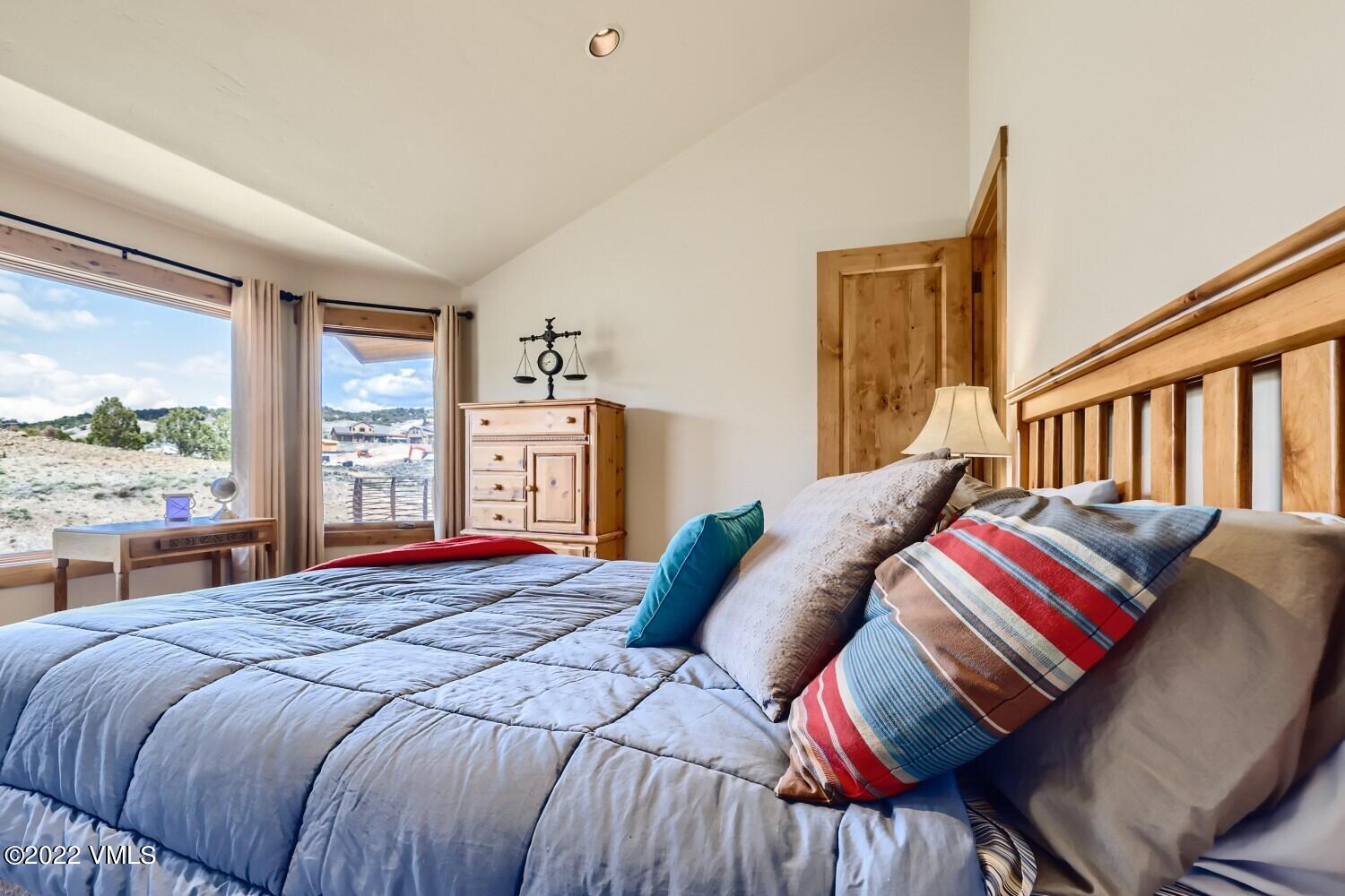290 Amherst Road Gypsum, CO 81637 - Photo 15 of 32 a bedroom with a bed and wooden floor