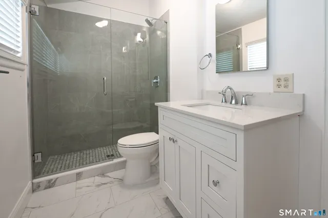 a bathroom with a sink a toilet and shower