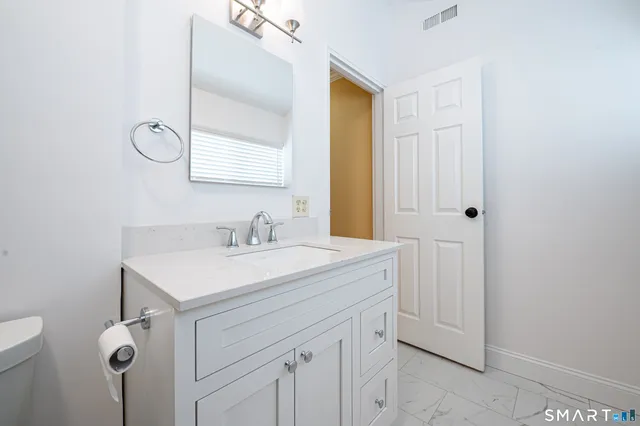 a bathroom with a sink vanity and a mirror