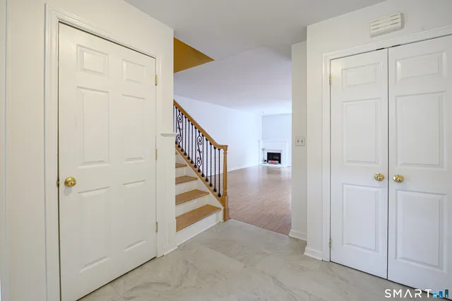 an entryway with wooden floor and staircase