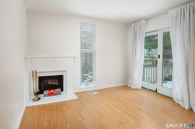 an empty room with floor to ceiling window and fireplace