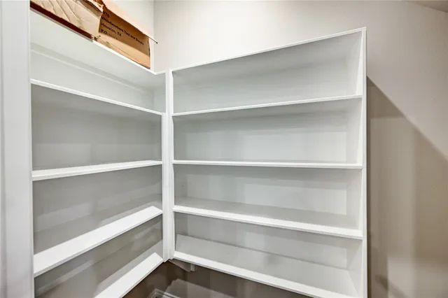 a view of walk in closet with empty racks